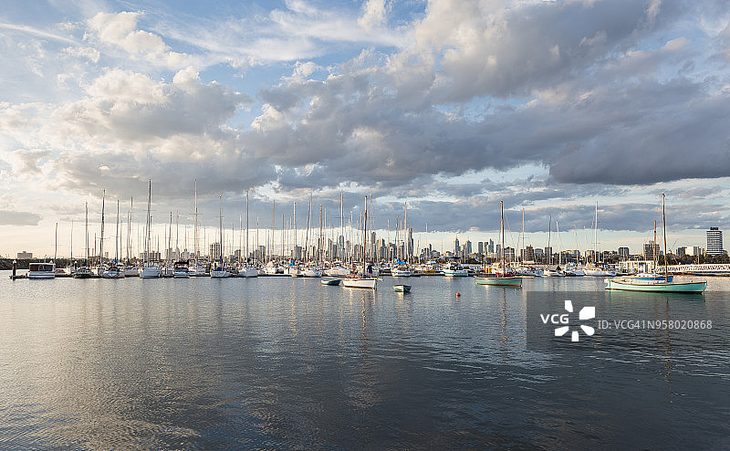 圣基尔达码头的船只在港口，墨尔本，澳大利亚。墨尔本CBD和金融大厦落后。图片素材