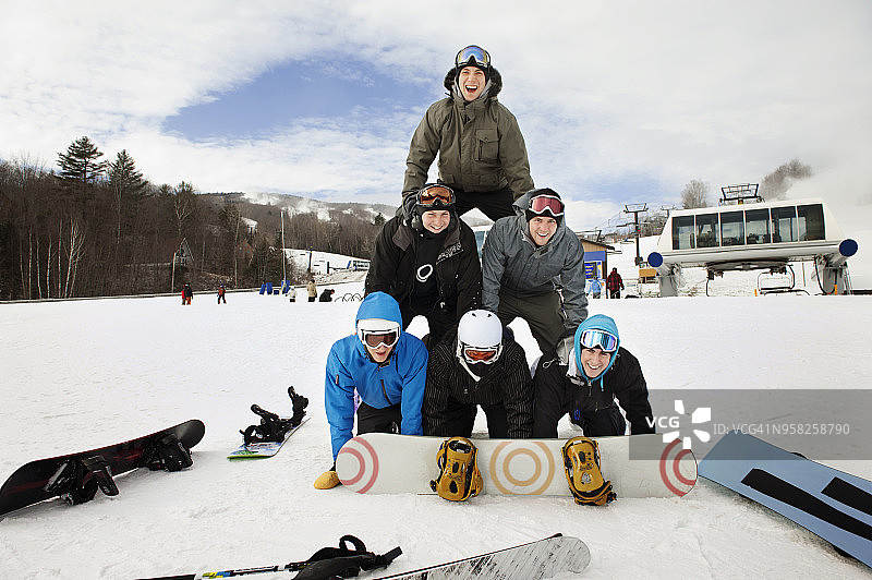 快乐的滑雪者在雪地上形成金字塔的肖像图片素材