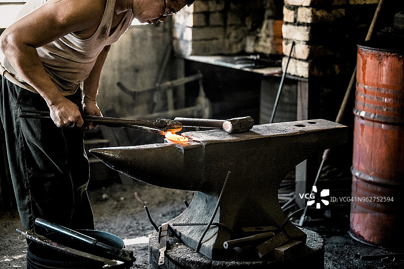 铁匠用锤子打铁图片素材