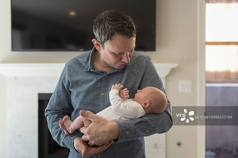 父亲抱着刚出生的男婴在家图片素材
