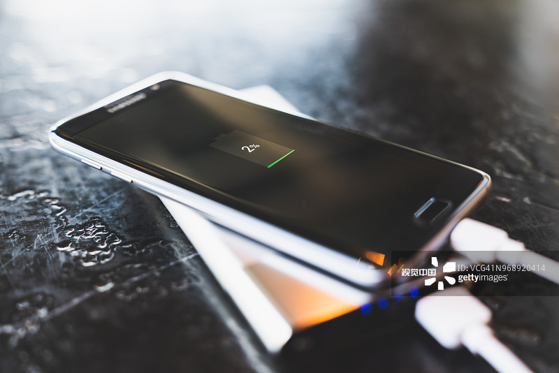 泰国曼谷——2018年5月24日:三星Galaxy S7 Edge智能手机通过动力银行电池充电器充电。说明编辑图像。图片素材