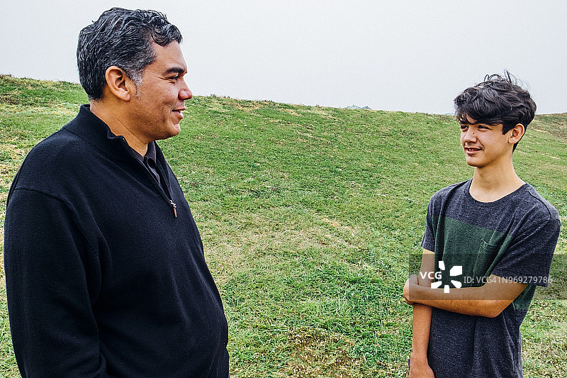 父亲和十几岁的儿子在公园聊天图片素材
