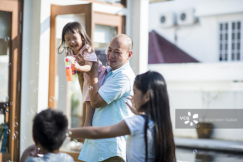 中国家庭在前院玩泡泡图片素材