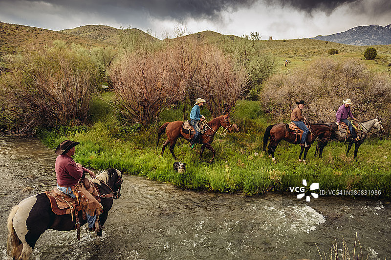 犹他州的牧场主骑着马过河图片素材