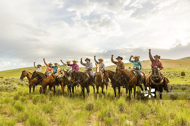 在美国犹他州盐湖城的桑塔昆山谷，牛仔们在乡间一起行礼图片素材