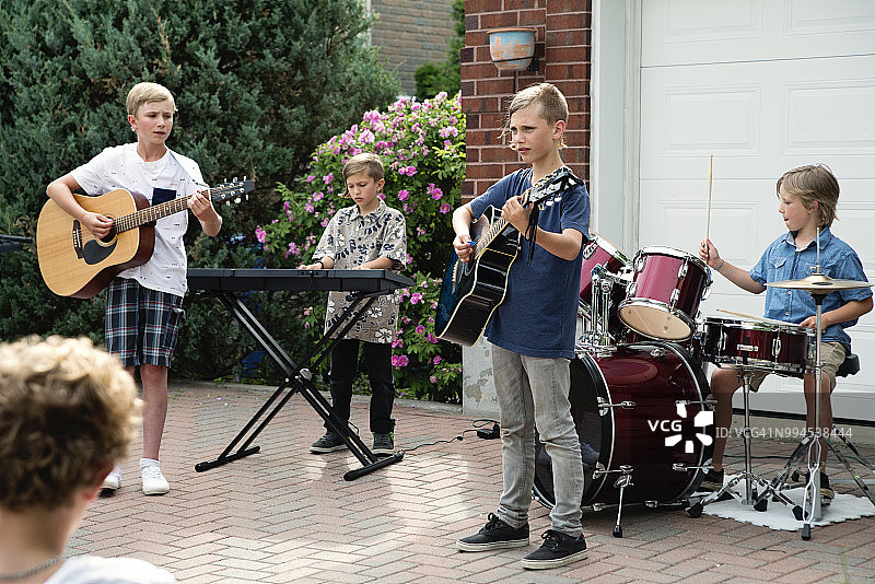 夏天，男孩乐队在自家车道上举行音乐会。图片素材
