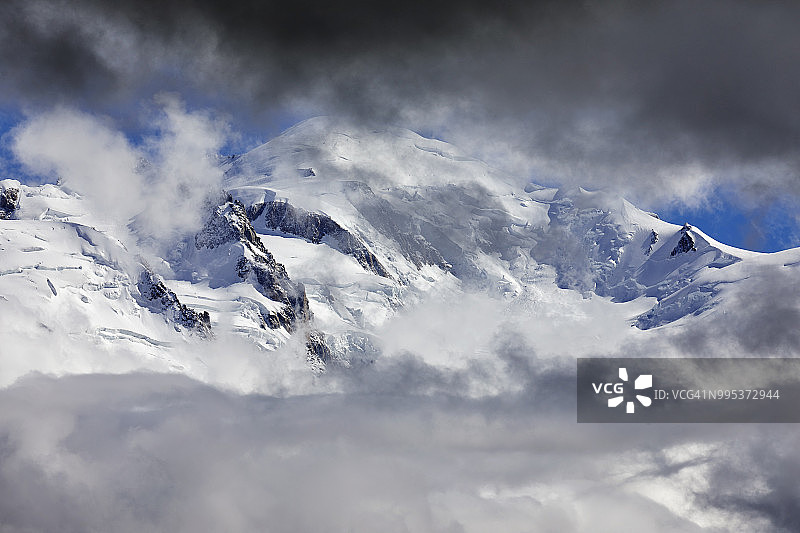 梦幻的风景。透过云层望向高空，白雪皑皑的群山图片素材