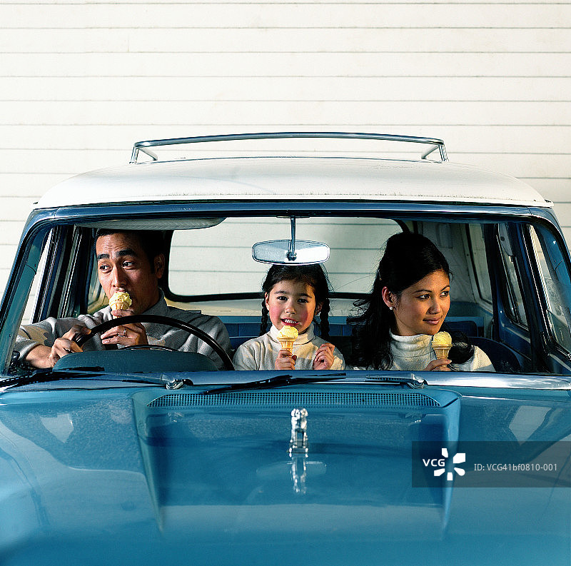 一对年轻夫妇带着女儿(4-6岁)在车里吃冰淇淋图片素材
