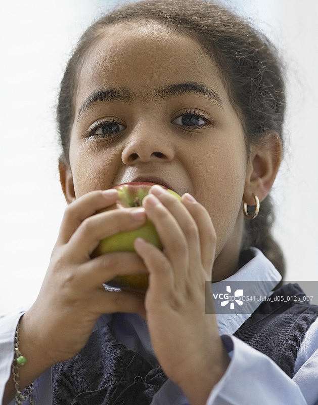 一个吃苹果的女孩的肖像图片素材