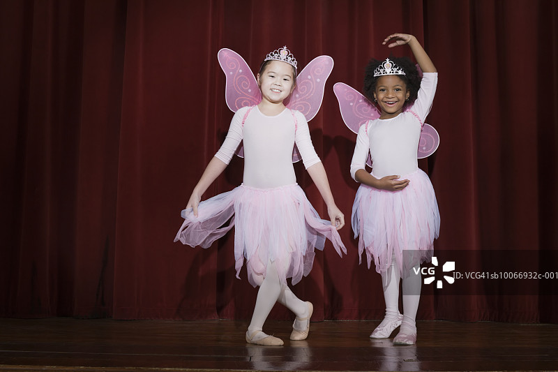女孩们(6-9)微笑着在舞台上表演芭蕾舞图片素材