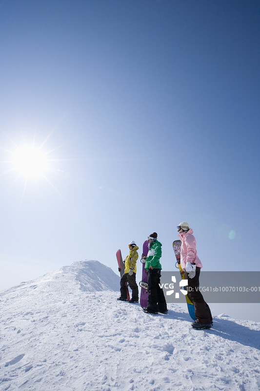 斜坡上有三个滑雪板运动员图片素材