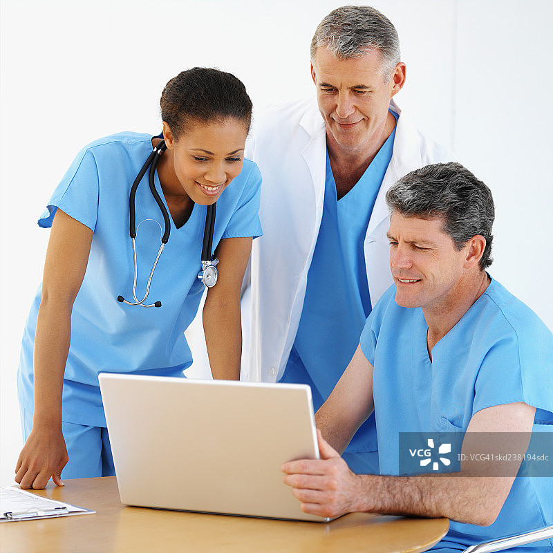 三个医务人员在笔记本电脑上工作的特写图片素材