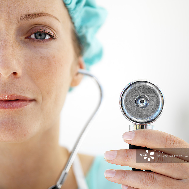 女医生戴着防护帽并使用听诊器的女医生图片素材