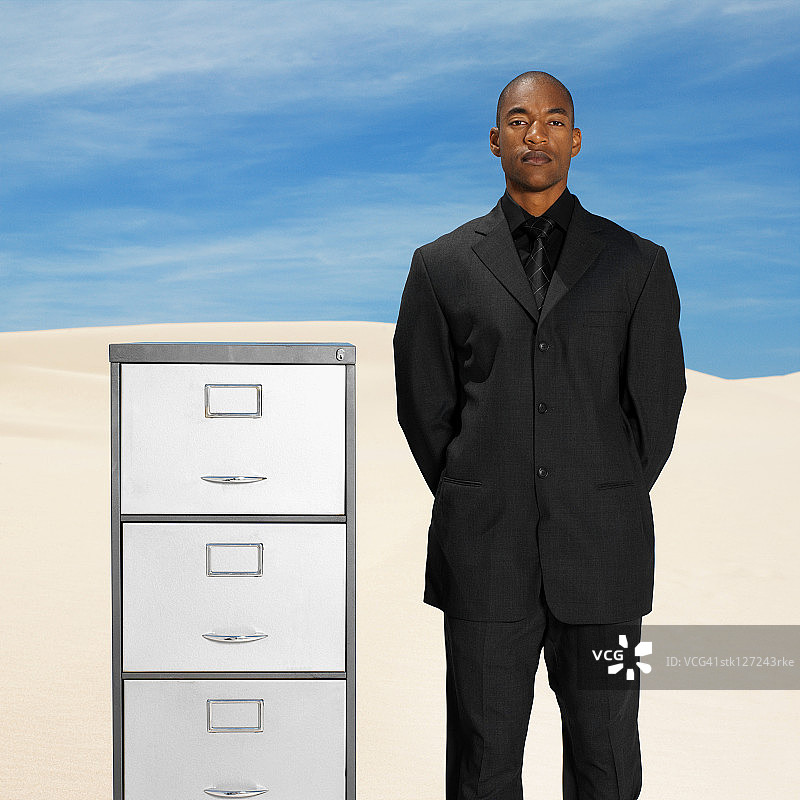 商人和文件柜在沙漠，低角度查看，肖像图片素材