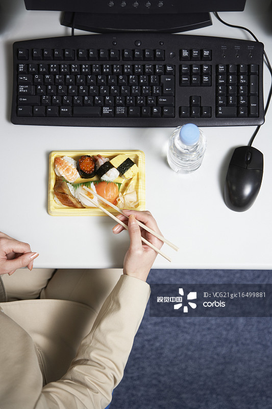 女商人在办公桌上吃寿司图片素材