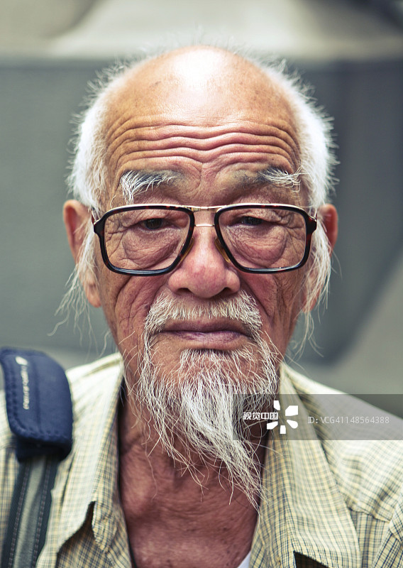 一位戴眼镜的老人的肖像。图片素材