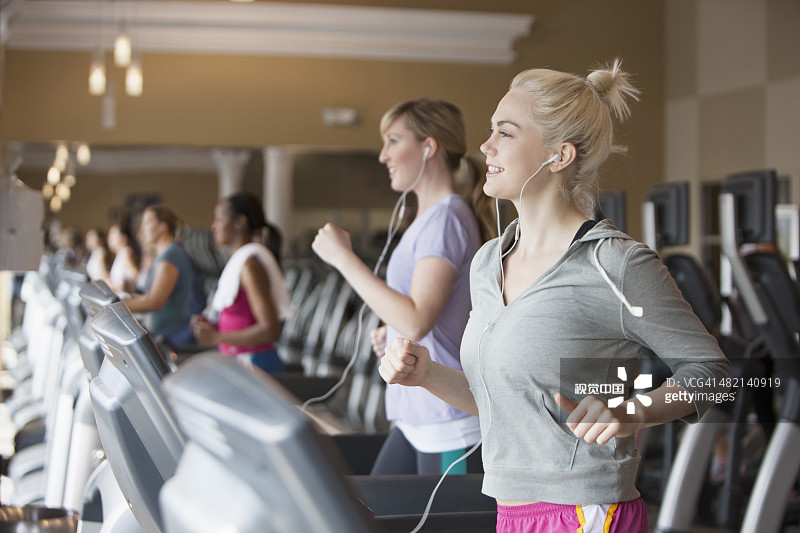 白人女性在健身房的跑步机上锻炼图片素材