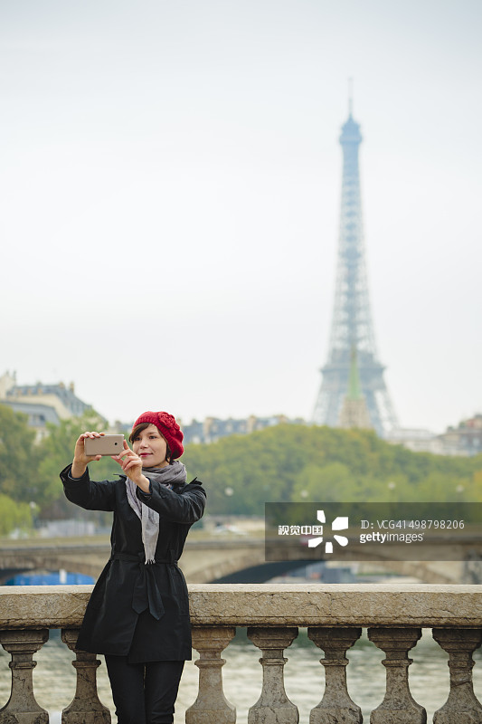 一名女子在巴黎与埃菲尔铁塔自拍。图片素材