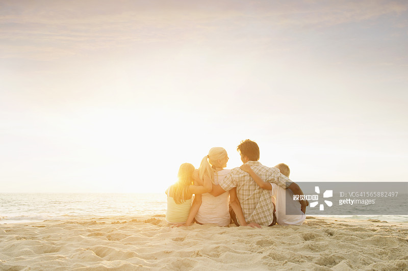 一个白人家庭坐在海滩上图片素材
