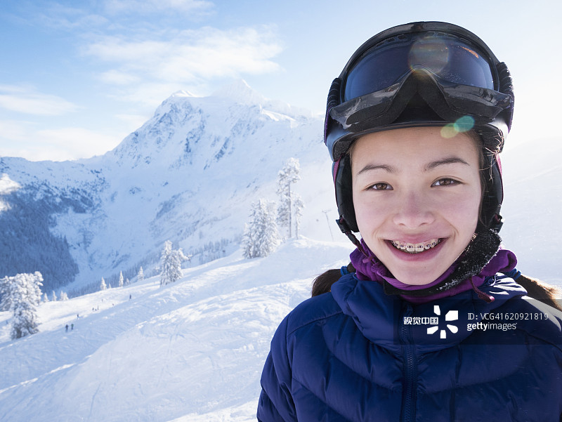 混血女孩在雪山上微笑图片素材