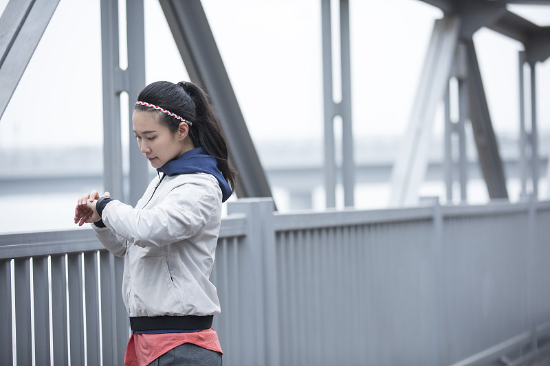 青年女子在跨海大桥上查看智能手表图片下载