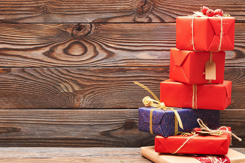 有创意的包装和装饰的圣诞礼物盒在木制背景。副本的空间。图片素材