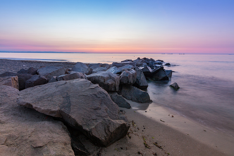 日出时海面上的岩石图片素材