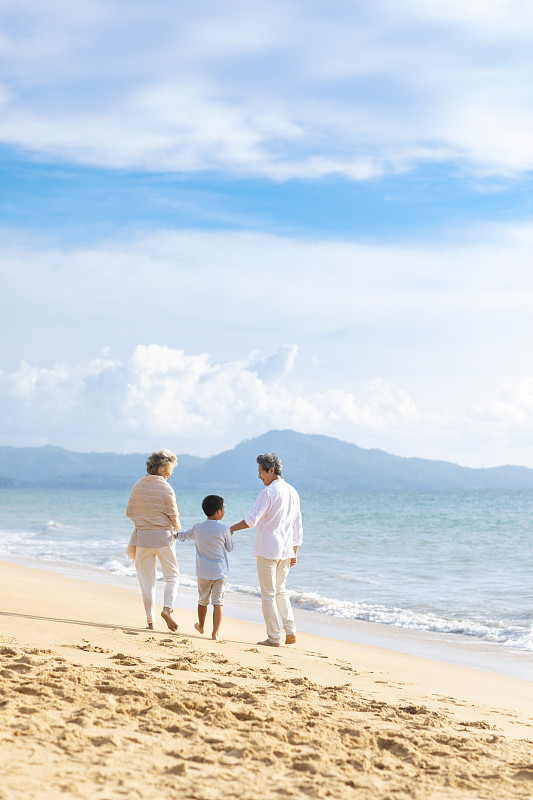 快乐的家庭在沙滩漫步图片素材