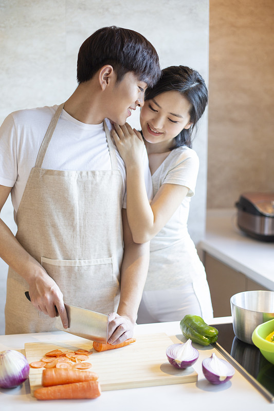 年轻情侣在厨房做饭图片下载