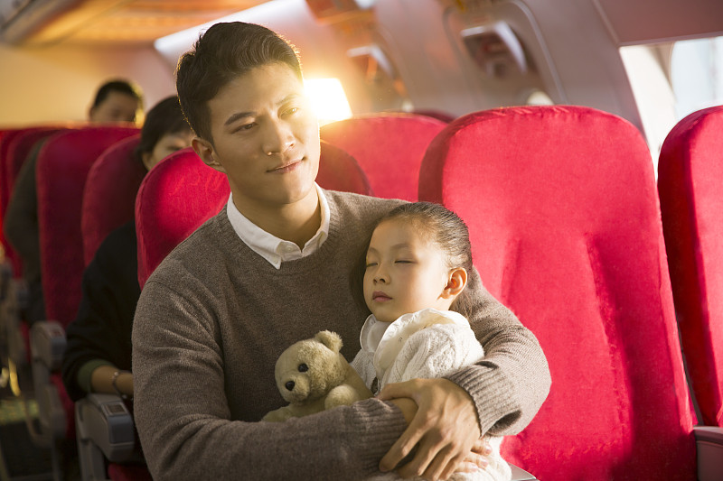 爸爸抱着女儿在飞机上睡觉图片下载