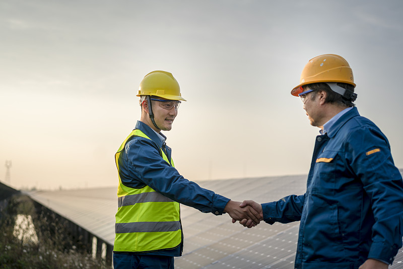 两个亚洲男性工程师在太阳能电池板前图片下载