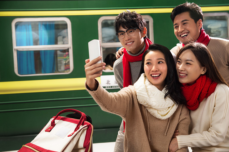 青年男女在火车站台上用手机图片下载