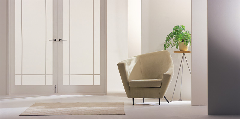 现代化的椅子，门旁边的桌子上有一盆植物图片素材