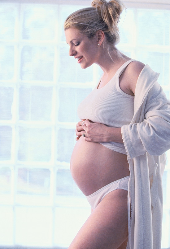 孕妇向下看腹部，侧视图图片下载