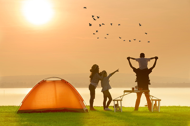 在日落时分，一家人在湖边的帐篷边欣赏天空图片下载