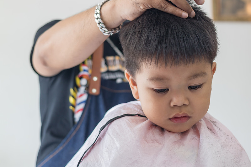 理发师在沙龙中剪男孩的头发图片素材