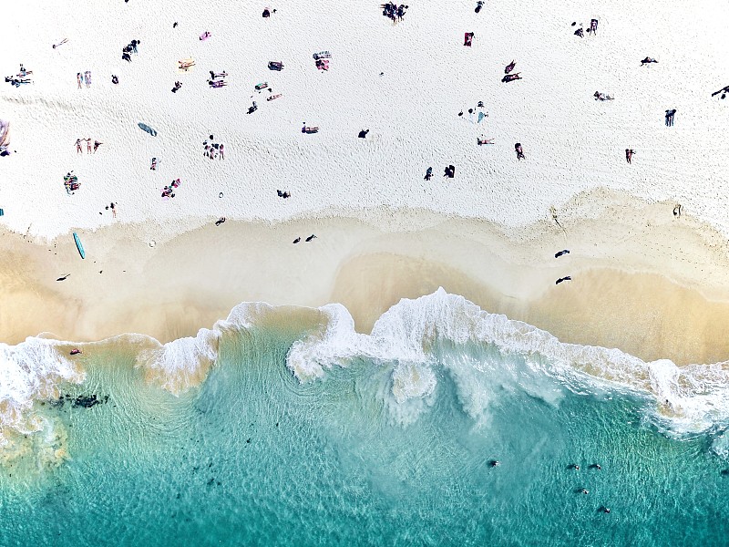 从空中拍摄的人们坐在海滩上的照片摄影图片