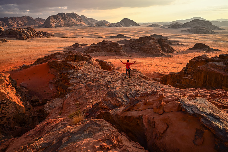 约旦瓦迪拉姆沙漠的红色沙丘和神奇岩石的日出景象图片下载