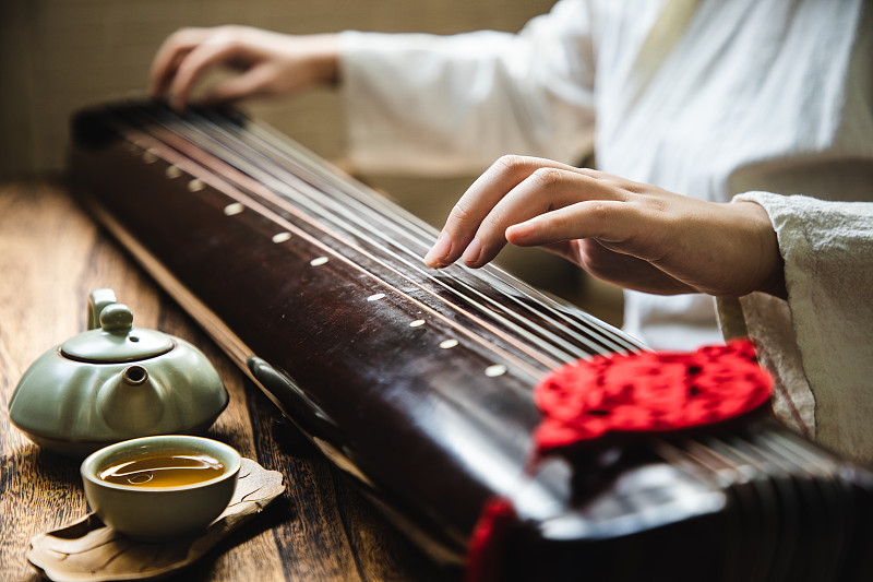 弹奏古琴(一种中国古代弦乐器)的亚洲妇女图片素材