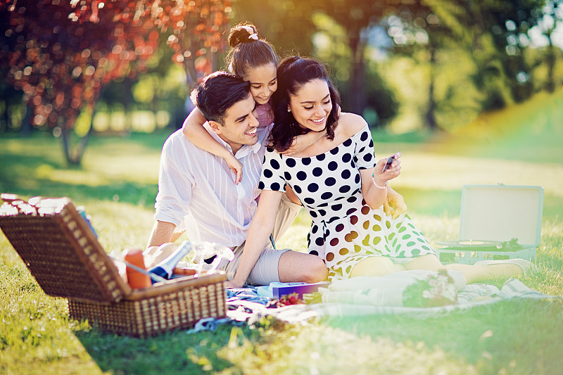 快乐的家庭是在公园野餐看即时照片摄影图片下载