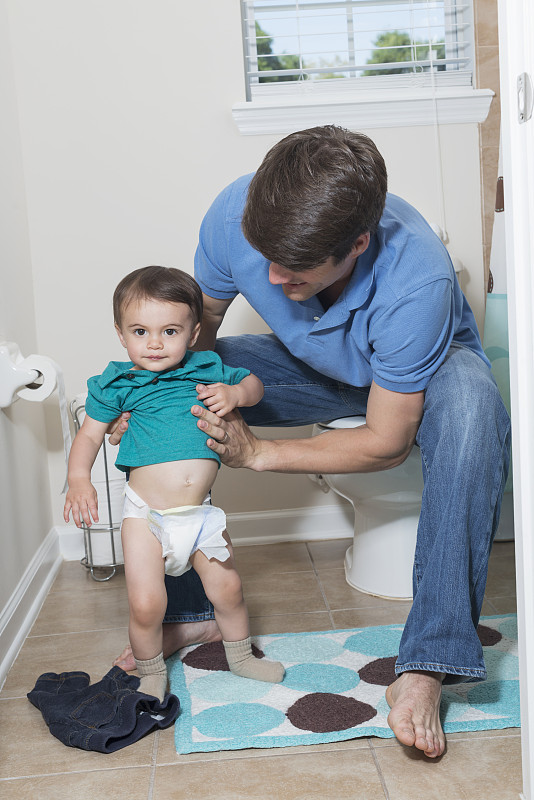 父亲在浴室和1岁的孩子，换尿布图片下载