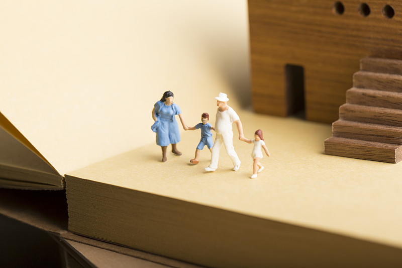 创意保险一家四口小玩偶、房子和书籍静物图片下载