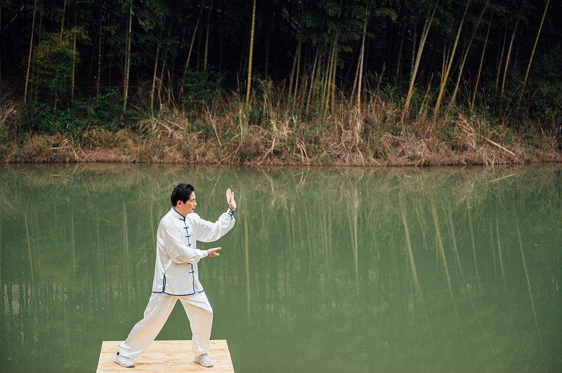 亚洲老年男性在湖边打太极拳图片下载