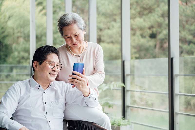 亚洲老年夫妇使用智能手机图片素材