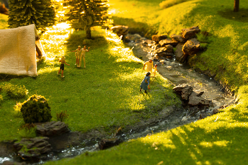 夕阳下小人模型户外微景观露营郊游创意静物图片素材