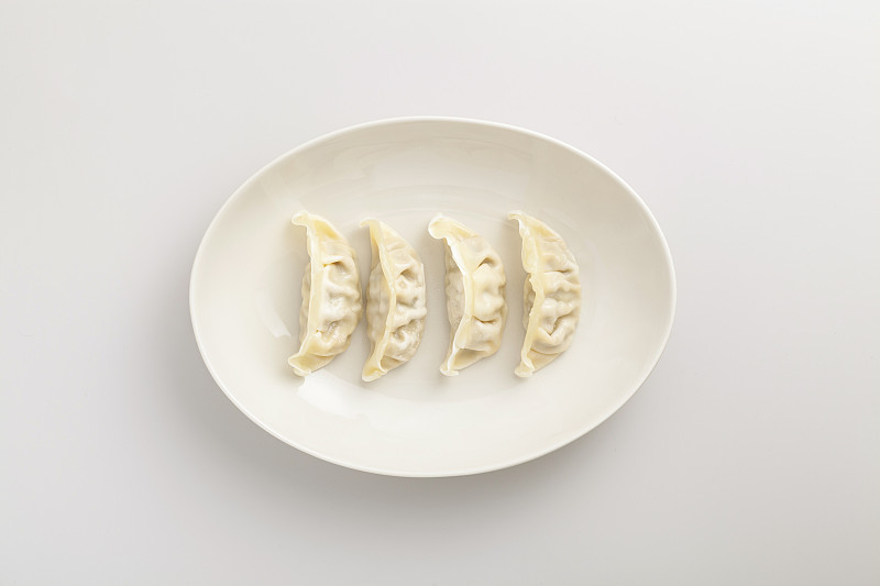 摆放在白色盘子上的新年饺子图片下载
