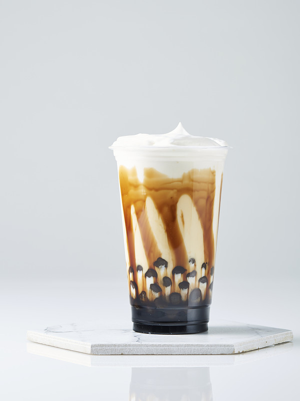 红糖奶茶，木薯珍珠和鲜奶油在白色的背景图片下载