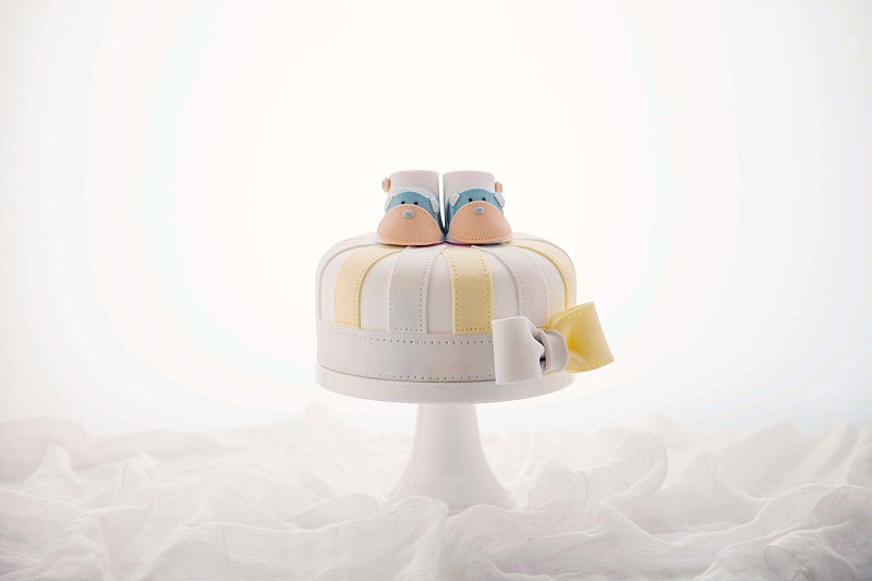 一张明色调的摆放中间位置的翻糖蛋糕的照片摄影图片