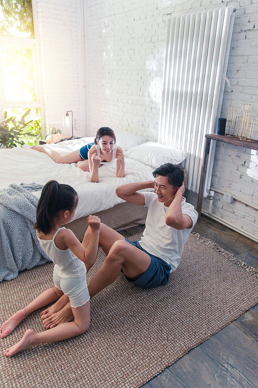 卧室内快乐运动的三口之家图片素材