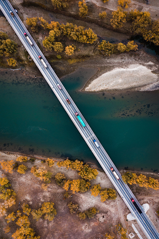 金秋时节新疆的一座桥上前赴后继的卡车货车图片素材